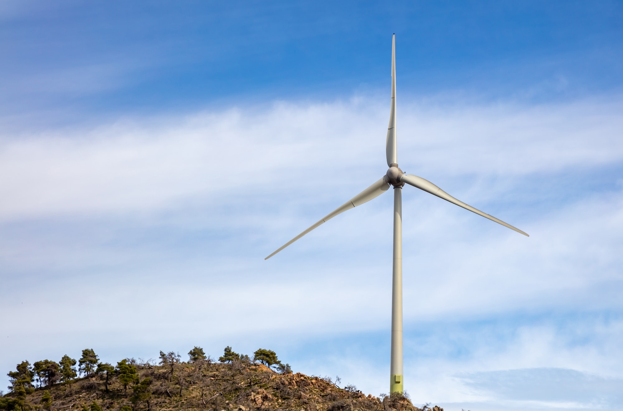 Single wind turbine located on a rocky hilltop